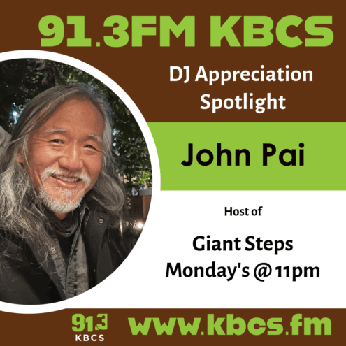 A KBCS DJ appreciation poster with an image of John Pai, the host of Giant Steps. He is an asian man with long grey hair, a short beard, and he is smiling while looking into the camera. He is outside with trees and lights behind him.