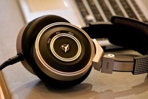 Pair of professional headphones on desk with keyboard in the background.