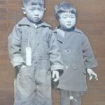 Erin Shigaki's mural of two Japanese American children in a black and white photograph against a campus building.