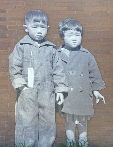 Erin Shigaki's mural of two Japanese American children in a black and white photograph against a campus building.