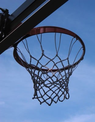 Underneath a basketball hoop with blue sky in the background.