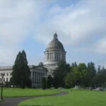 Legislative building in Olympia, WA surrounded by grass, trees, and a path.