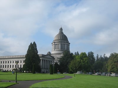 Legislative building in Olympia, WA surrounded by grass, trees, and a path.